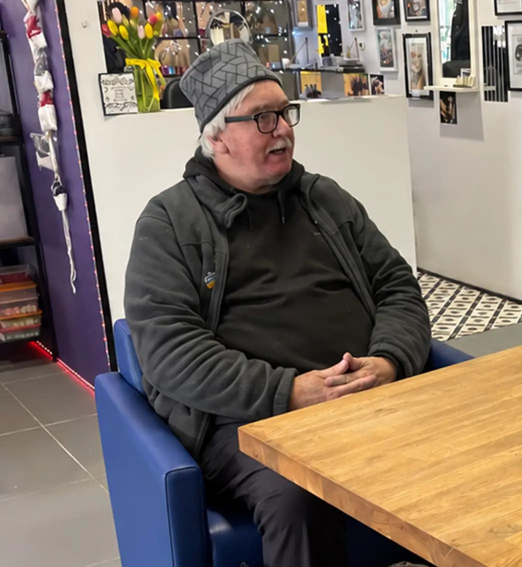 An image of a man sitting at a table having a conversation